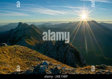 Tôt le matin avec une belle lumière du soleil avec de l'herbe dorée et une superbe crête dans les montagnes. Banque D'Images