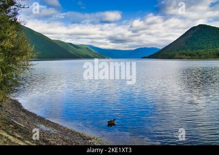 Nuages et ciel bleu se reflétant dans l'eau du lac Rotoroa, parc national des lacs Nelson, région de Tasman, Île du Sud, Nouvelle-Zélande. Banque D'Images