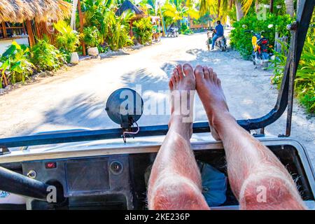 Promenade en voiturette de golf avec les pieds vers le haut sur l'île Isla Holbox à Quintana Roo Mexique. Banque D'Images