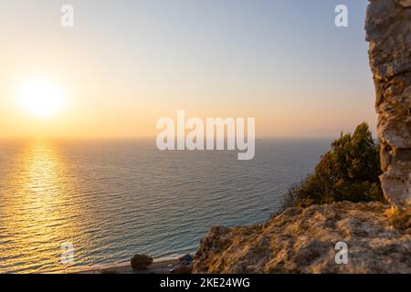 Vue panoramique sur la mer Méditerranée depuis une plage de sable avec des rayons de soleil sur fond de coucher de soleil coloré de Rhodes, Grèce. Vacances, concept de vacances. Photo de haute qualité Banque D'Images