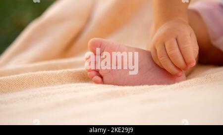 Mise au point douce, Gros plan de petits pieds de bébé sur un arrière-plan couvert léger. Photo de haute qualité Banque D'Images