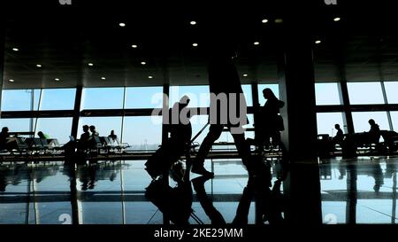 à l'aéroport, dans la salle d'attente, sur le fond de la fenêtre donnant sur les avions et la piste, les silhouettes marchent, ils se précipitent sur leurs vols. Photo de haute qualité Banque D'Images