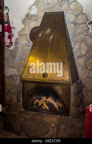 Le feu est allumé dans une cheminée en métal avec des portes en verre dans la salle de séjour de la maison de campagne. Concept de cheminée avec cheminée à la maison. Près du feu dans la cheminée Banque D'Images