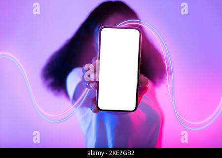 Femme noire méconnue se cachant derrière le téléphone avec écran vide, maquette Banque D'Images