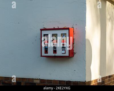 Vieux distributeur automatique de gomme à bulles dans un bâtiment aux intempéries dans un quartier résidentiel. Bonbons et jouets pour enfants. La machine est périmée. Banque D'Images