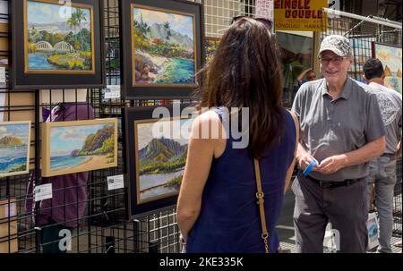 Honolulu, Hawaii, 8 octobre 2022 - Chinatown Street art show - Woman montre ses peintures à la vente. Banque D'Images