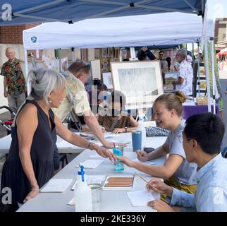 Honolulu, Hawaii, 8 octobre 2022 - Chinatown Street art show - les instrutiteurs d'artistes enseignent aux clients sur la peinture. Banque D'Images