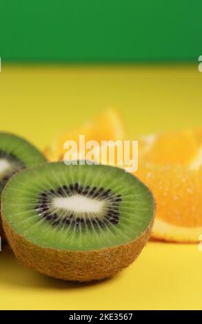 gros plan de kiwi et de tranches d'orange sur fond jaune Banque D'Images