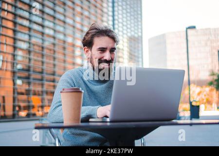 Portrait d'un jeune homme travaillant à distance depuis une terrasse de café et ayant un travail conférence appel vidéo avec un ordinateur portable. Concept d'entreprise Banque D'Images
