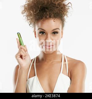 Besoin d'une marraine de fées Pourquoi ne pas essayer cette baguette magique. Photo en studio d'une jeune femme attrayante tenant une bouteille de mascara sur fond blanc. Banque D'Images