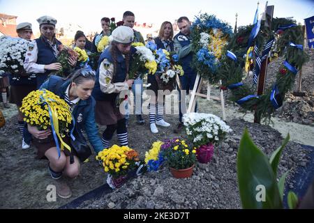 Lviv, Ukraine. 09th novembre 2022. Les gens placent des fleurs sur la tombe du soldat ukrainien Taras Havrylyshyn, mort à la suite de l'invasion militaire russe de l'Ukraine, au cimetière de Lychakiv à Lviv. Les funérailles de Taras Havrylyshyn, soldat de la Brigade d'artillerie des Forces armées ukrainiennes de 45th, ont eu lieu à Lviv. Il mourut en libérant des terres ukrainiennes des envahisseurs russes dans la direction du sud. Taras Havrylyshyn était un membre bien connu de l'organisation scoute ukrainienne 'Plast'. Crédit : SOPA Images Limited/Alamy Live News Banque D'Images