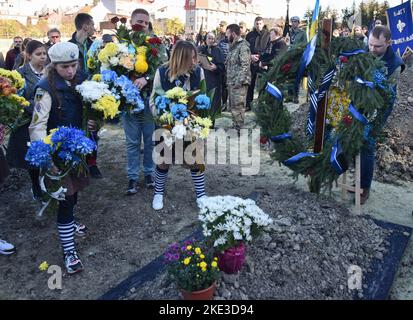 Lviv, Ukraine. 09th novembre 2022. Les gens placent des fleurs sur la tombe du soldat ukrainien Taras Havrylyshyn, mort à la suite de l'invasion militaire russe de l'Ukraine, au cimetière de Lychakiv à Lviv. Les funérailles de Taras Havrylyshyn, soldat de la Brigade d'artillerie des Forces armées ukrainiennes de 45th, ont eu lieu à Lviv. Il mourut en libérant des terres ukrainiennes des envahisseurs russes dans la direction du sud. Taras Havrylyshyn était un membre bien connu de l'organisation scoute ukrainienne 'Plast'. Crédit : SOPA Images Limited/Alamy Live News Banque D'Images