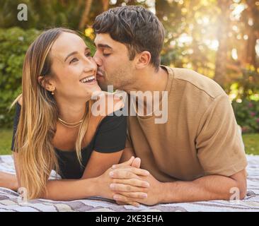 Couple, tenant les mains avec le baiser et l'amour dans le parc, pique-nique pour le collage et heureux dans la nature ensemble. Soutien, confiance et soin avec date romantique et Banque D'Images