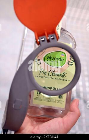 Karlsruhe, Allemagne. 03rd novembre 2022. Une personne regarde à travers la loupe sur un panier à un rince-bouche Alverde dans une branche de la chaîne dm de pharmacie, qui a imprimé 'Pro Climate écologiquement neutre produit'. La conférence de presse annuelle du groupe de pharmacies a lieu le 10 novembre 2022. Credit: Uli Deck/dpa/Alay Live News Banque D'Images