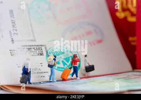 Installation d'un studio miniature Toys concept - un couple arrive ou part à l'aéroport avec la dame parle à son téléphone portable avec un visa passeport timbre Banque D'Images