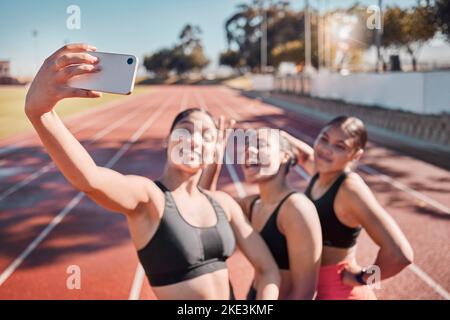 Fitness, selfie et athlètes s'entraînent sur une piste pour un marathon pour la santé, le bien-être et l'exercice. Sports, sourire et amis heureux de prendre une photo Banque D'Images