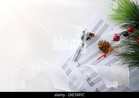 Concert de Noël d'instruments en laiton avec pièce de bouche et musique de feuille sur table blanche. Vue de dessus. Banque D'Images