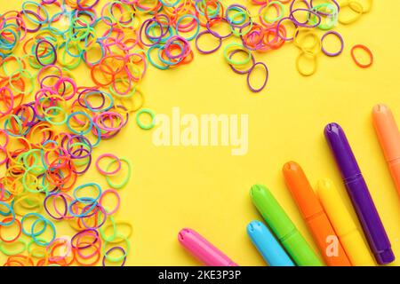 Bandes et marqueurs en caoutchouc colorés sur fond jaune Banque D'Images