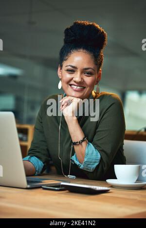 Les nuits tardives dans le bureau ne sont rien pour moi. Portrait d'une jeune femme attirante travaillant sur son ordinateur portable au bureau. Banque D'Images