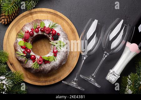 Gâteau de Noël décoré de graines de grenade, de canneberges et de romarin. Pose à plat Banque D'Images