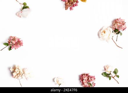 Cadre de fleurs d'automne aux couleurs rouge et bordeaux. Roses, hortensia. Composition florale sur fond blanc. Banque D'Images