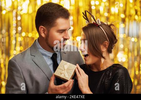 Couple avec cadeau d'or pour le nouvel an ou la fête de Noël Banque D'Images