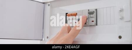 Man active l'interrupteur à bascule avec le bouton de fermeture de la main Banque D'Images