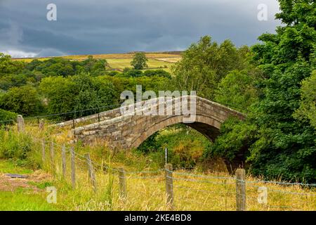 Duck Bridge près de Danby dans le nord du Yorkshire Angleterre Royaume-Uni un pont à cheval postmédiéval au-dessus de la rivière Esk construit de grès courgé à chevrons. Banque D'Images