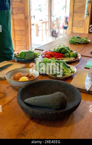 cours de cuisine indonésienne avec des ingrédients frais sur une table en bois. Plusieurs bols, avec salade fraîche, œufs etc Banque D'Images