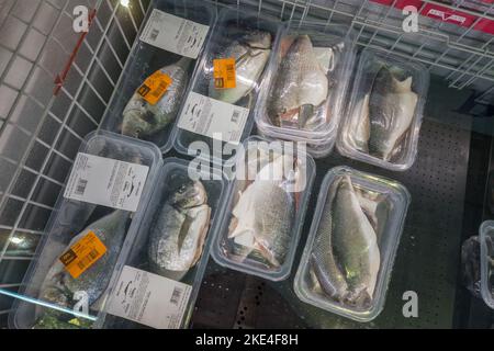 Fossano, Italie - 11 novembre 2022: Poisson de la dorade de mer vidé dans des emballages en plastique vendus dans le comptoir réfrigéré d'un supermarché italien Banque D'Images