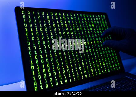 Concept de sécurité CIBER. Main gantée, code binaire et mot de cybersécurité sur l'écran de l'ordinateur portable Banque D'Images