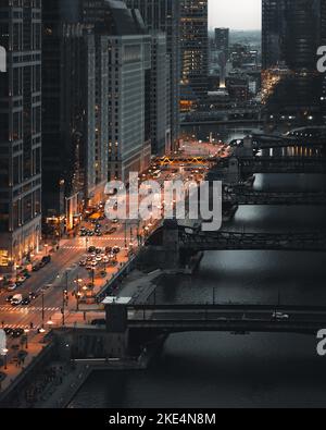 Une photo prise d'un gratte-ciel, en regardant sur une rue animée et de nombreux ponts traversant une rivière dans la soirée Banque D'Images