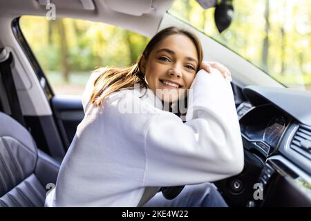 Conduire autour de la ville. Young attractive woman smiling et à tout droit en conduisant une voiture Banque D'Images