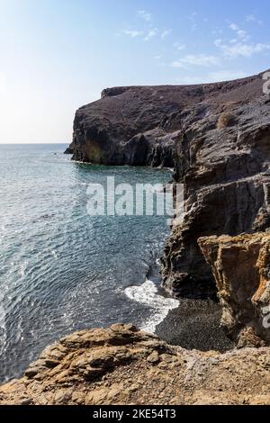 Côte rocheuse avec ciel bleu par une journée ensoleillée près de Playa Mujeres, Lanzarote, îles Canaries, Espagne. Banque D'Images