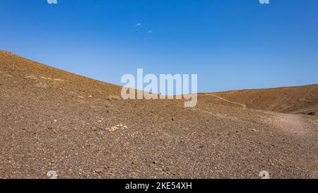 Homme marchant à l'horizon sur une dune de sable désertique vide à Playa Mujeres, Playa Blanca, Yaiza, Lanzarote, Las Palmas, Islas Canarias, Espagne, Europe. Banque D'Images