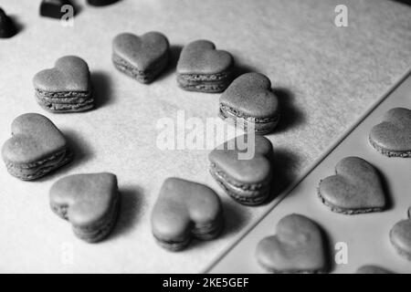 Macarons à coeur noir et blanc dessert sur papier sulfurisé Banque D'Images