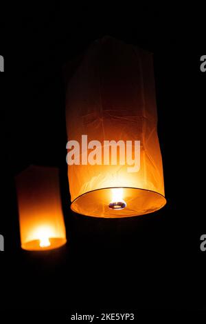Deux lanternes éclairées flottant pendant le Yi Peng Lantern Festival à Chiang Ma sous le ciel noir foncé Banque D'Images