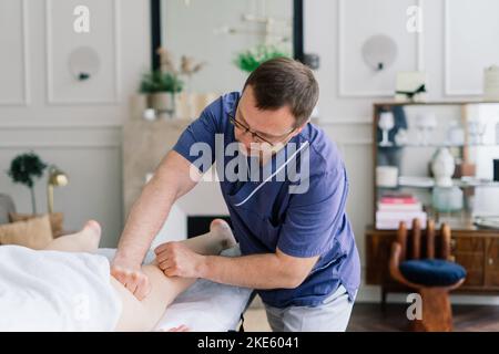 Une jeune femme de gras reçoit un massage dans un cabinet de spa de jour. Banque D'Images