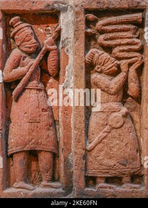 Gros plan de l'ancienne scène de sculpture en terre cuite de l'homme soufflant la corne à Kantaji aka Kantajew temple hindou médiéval à Kantanagar, Dinajpur, Bangladesh Banque D'Images