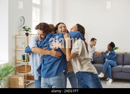 Des amis heureux qui ne se sont pas vus les uns les autres depuis longtemps s'embrasent pendant la réunion à la maison. Banque D'Images