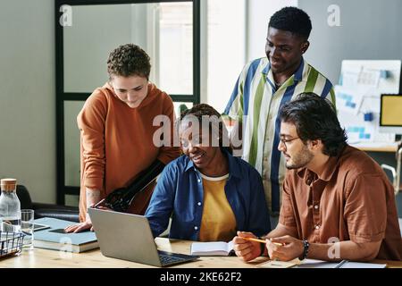 Groupe d'employés interculturels à l'écoute de jeunes collègues afro-américains qui font un rapport ou une présentation lors d'une réunion Banque D'Images