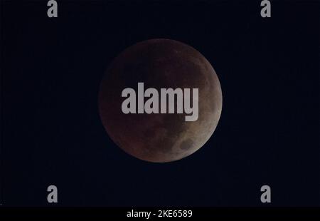 Kennedy Space Center, États-Unis d'Amérique. 08 novembre 2022. La pleine Lune apparaît comme une lune de sang au cours d'une éclipse lunaire totale dans le ciel nocturne au-dessus du Centre spatial Kennedy, 8 novembre 2022, à Cape Canaveral, Floride. Credit: Joel Kowsky/NASA/Alamy Live News Banque D'Images