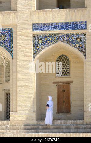 Boukhara Ouzbékistan une femme debout à l'ombre devant le Mir I Arab Madrasa décoré en août 2022 Banque D'Images