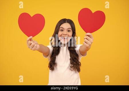 Saint-Valentin. Rêvant enfant adolescent mignon avec coeur rouge. Bonne adolescente, émotions positives et souriantes de la jeune fille. Banque D'Images