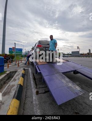 Voiture cassée sur le camion au bord de la route. Banque D'Images