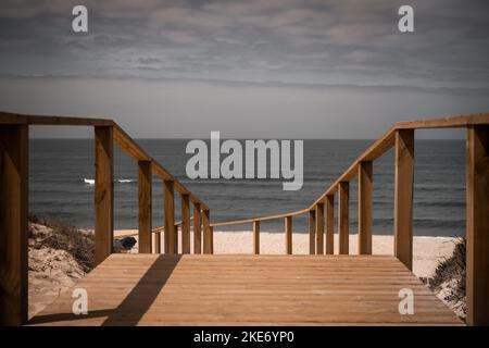 Promenade en bois menant à la plage et à l'océan Atlantique. Photographie de paysage à la plage de Quiaios au Portugal dans des couleurs désaturées Banque D'Images