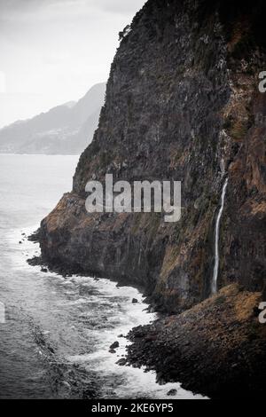 Paysage de l'île de Madère de Veu da Noiva ou cascade de Veil de la mariée qui coule des rochers dans l'océan et vu du point de vue ci-dessus. Image en tons Banque D'Images