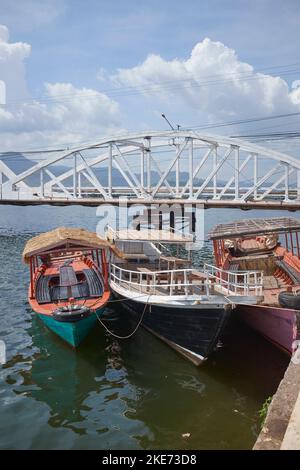 Bateaux attachés au quai en face du nouveau pont Etanou dans le centre-ville de Kampot Cambodge Banque D'Images