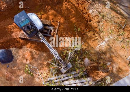 Au cours des travaux d'aménagement paysager avec des tracteurs, plusieurs sections de terrain ont été défrichées des racines d'arbres pour le développement de lotissements. Banque D'Images