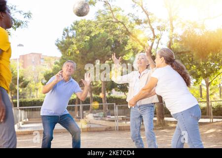 De vieilles multinationales jouent au volley-ball sur une aire de jeux d'été pour les sports au printemps dehors Banque D'Images